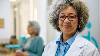 Portrait of smiling female doctor at medical clinic looking at camera.