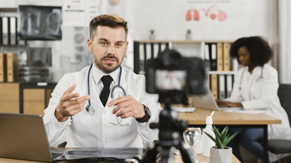 Qualified doctor using laptop and camera for recording video