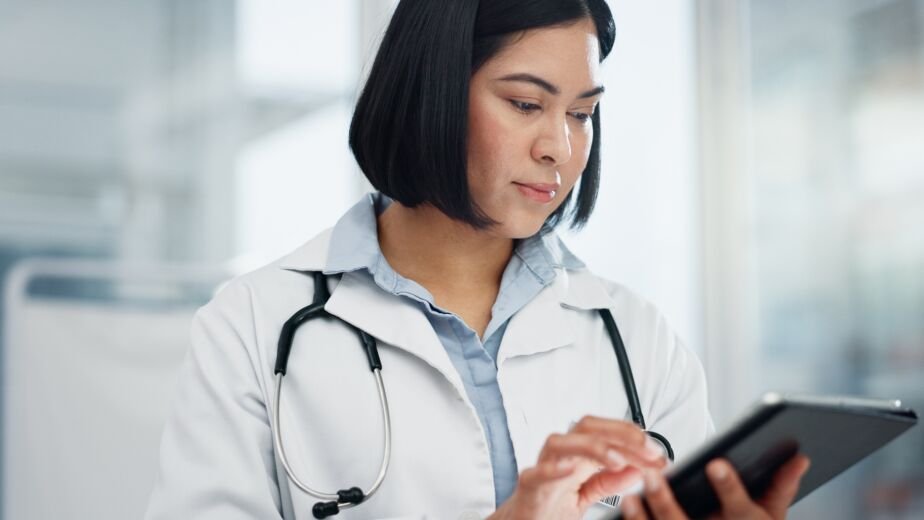 Woman, doctor and tablet for healthcare search, typing and clinic or hospital software, telehealth